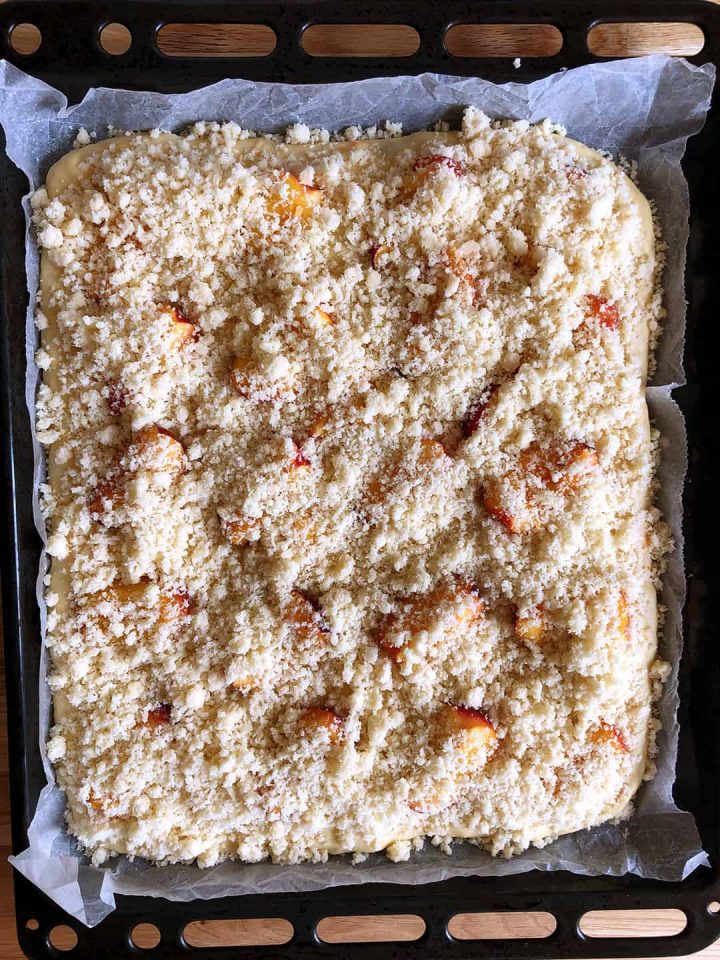 Yeast cake topped with fruit and crumble before baking.