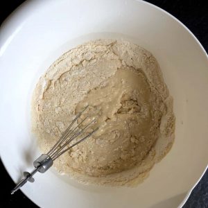 Combining ingredients for a yeast cake with a whisk.