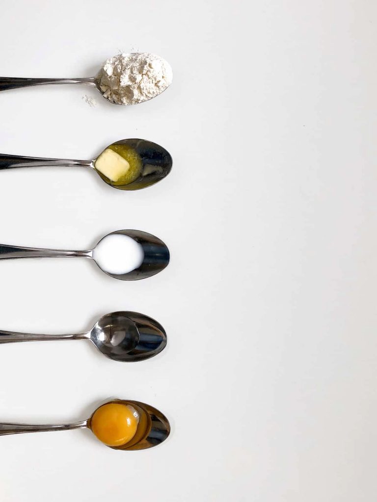 spoons with ingredients for pancake batter