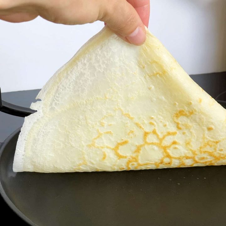 a hand lifting an edge of a pancake