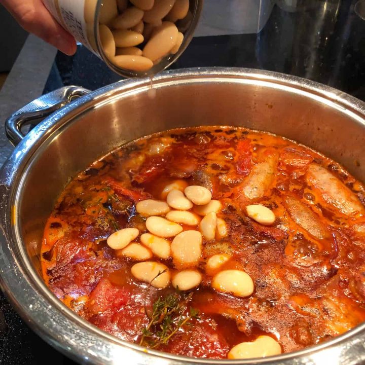 tipping butter beans into the casserole