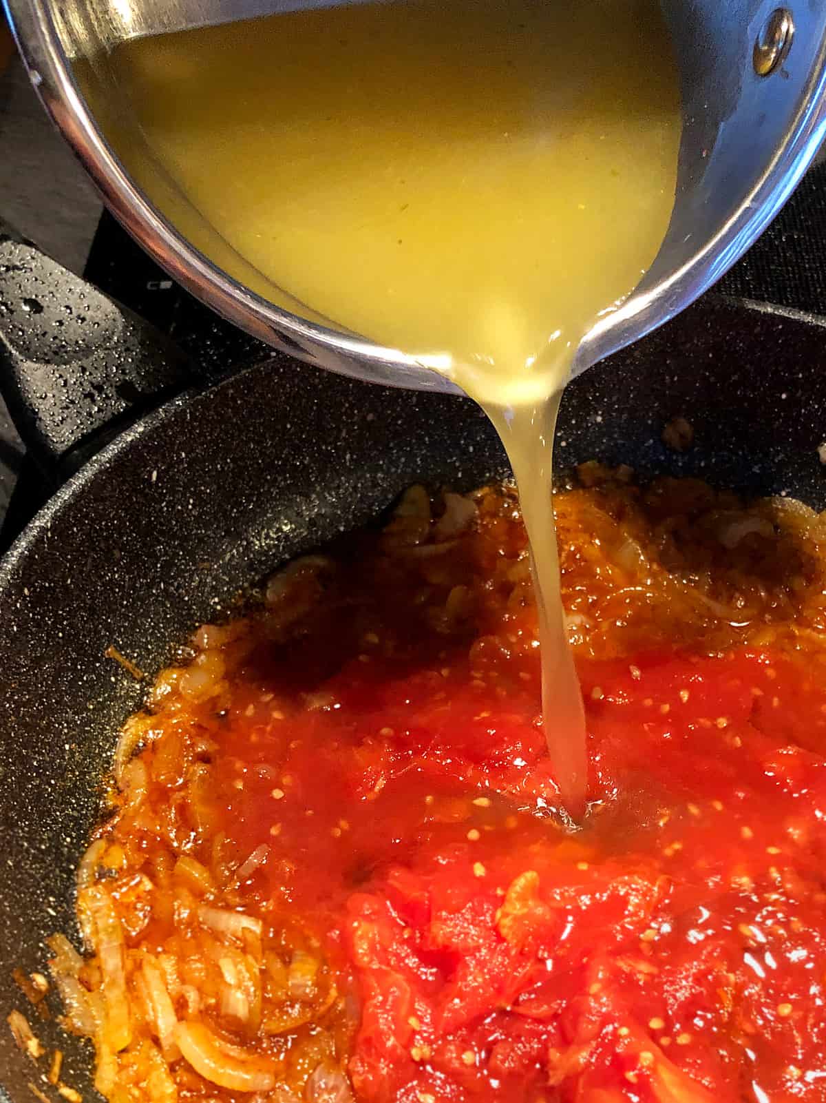 pouring stock into the pan