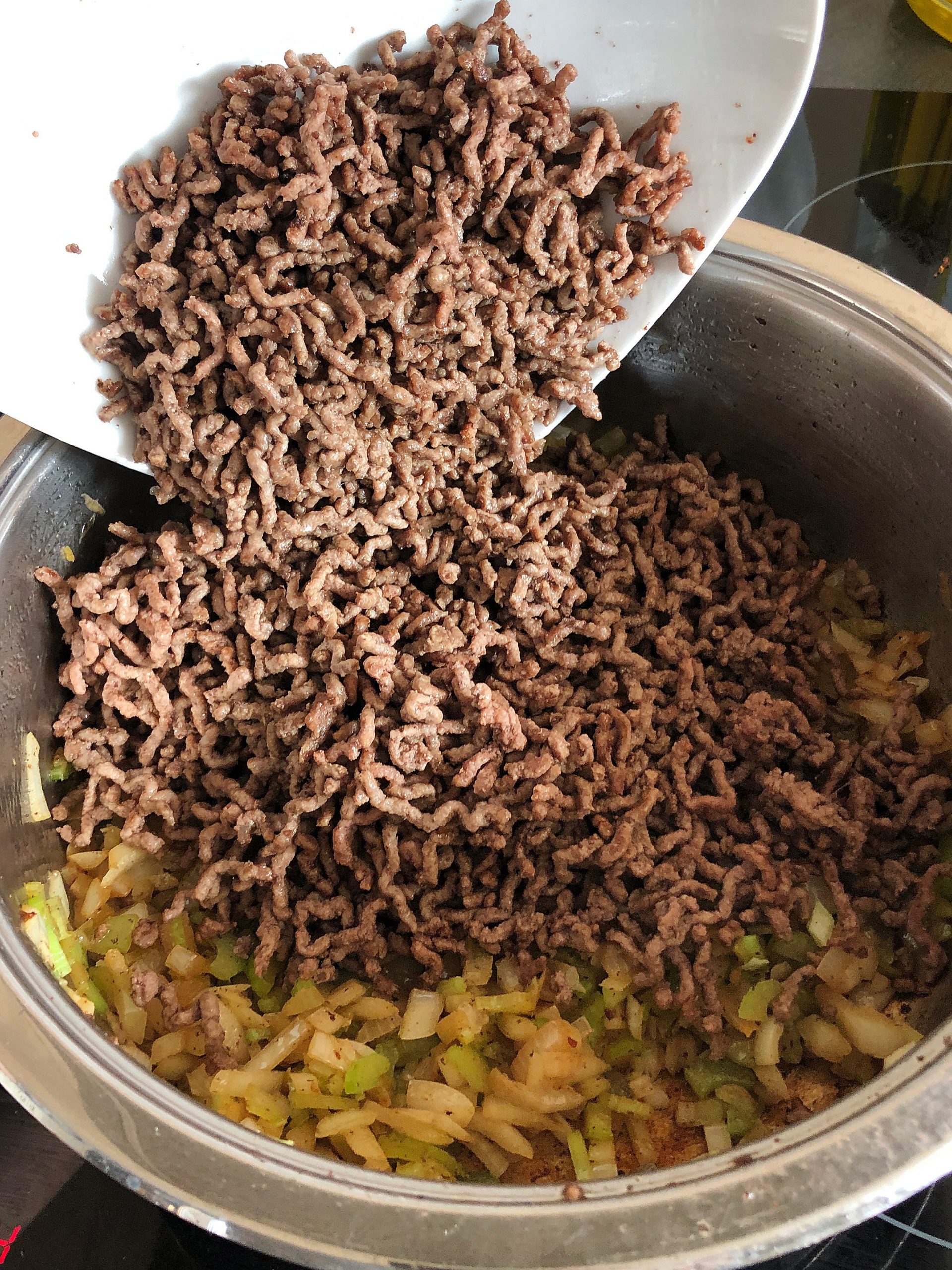 Adding browned minced beef into the frying pan