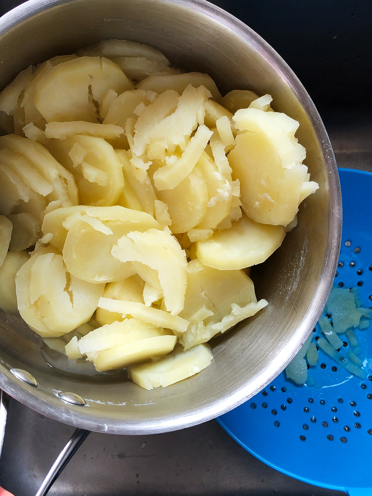 over-cooked potato slices in a pot