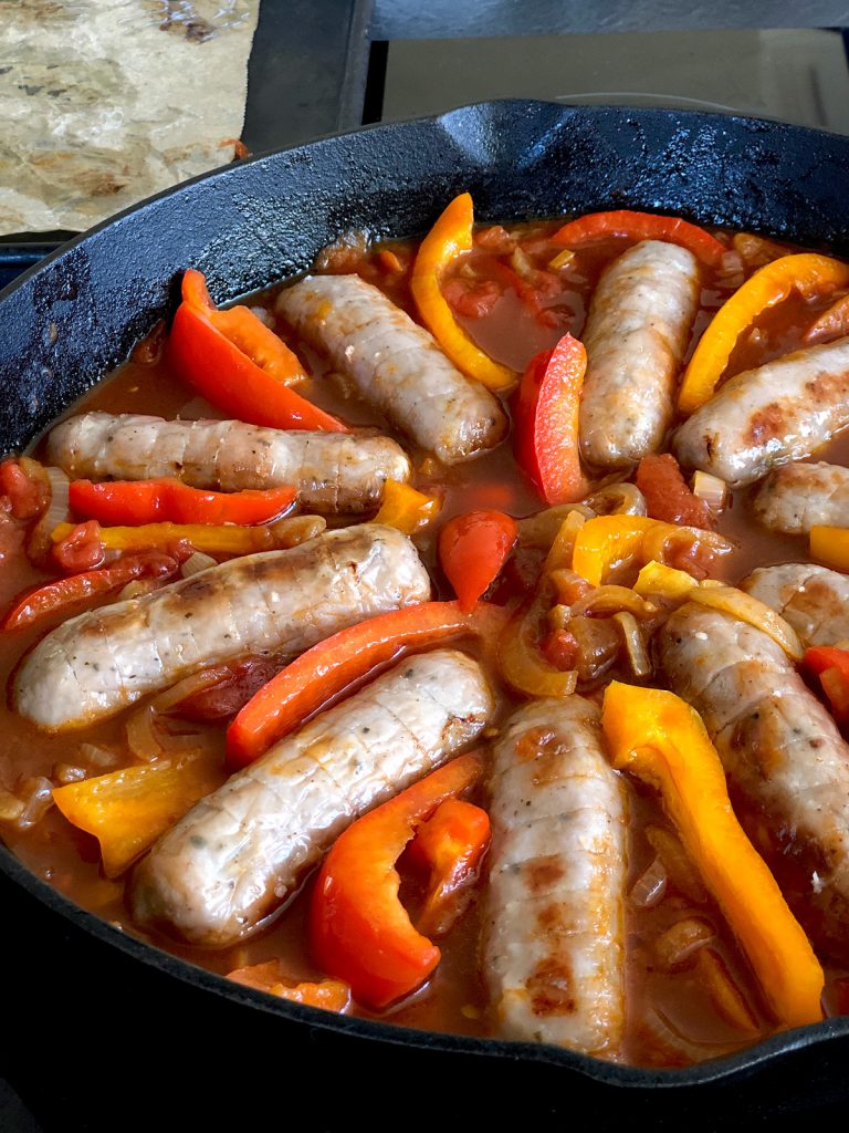 Sausages and bell peppers in a cast iron pan