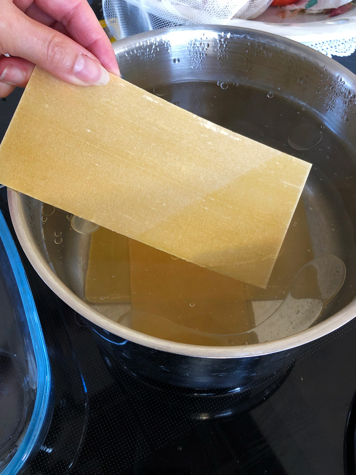 Pre-soaking dried lasagne in hot water.