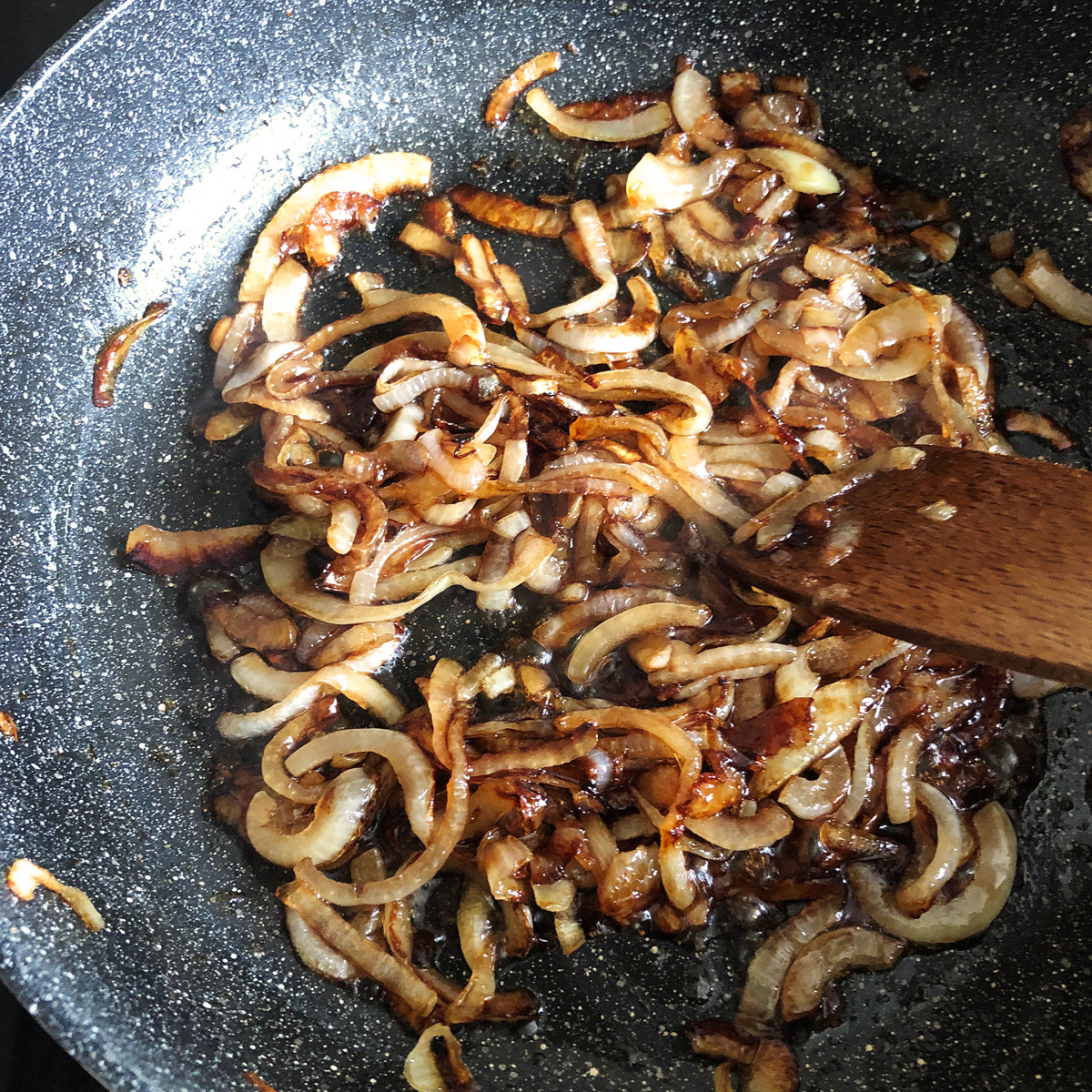 Golden-brown caramelised onion in a non-stick pan.