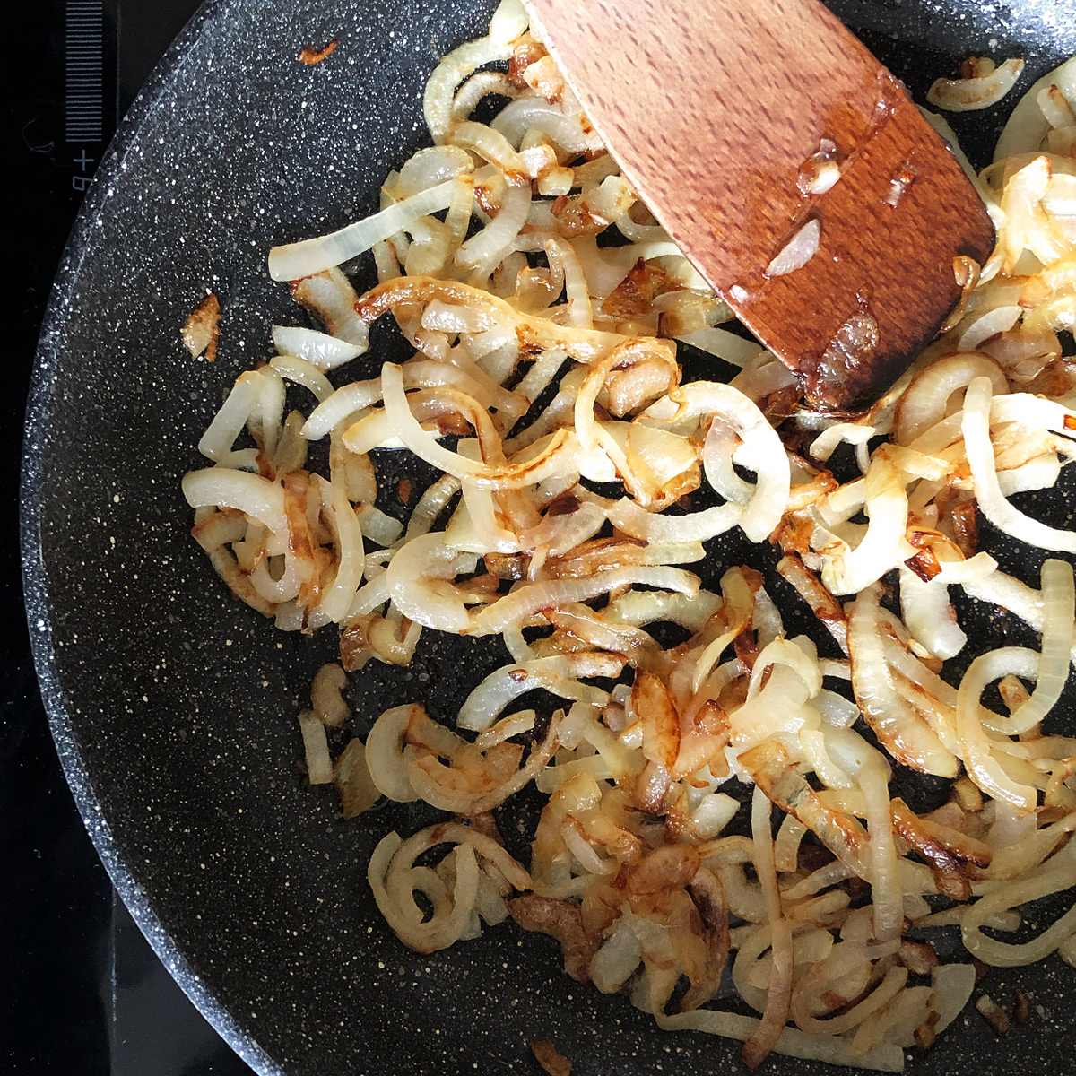Frying a onion in a non-stick pan.