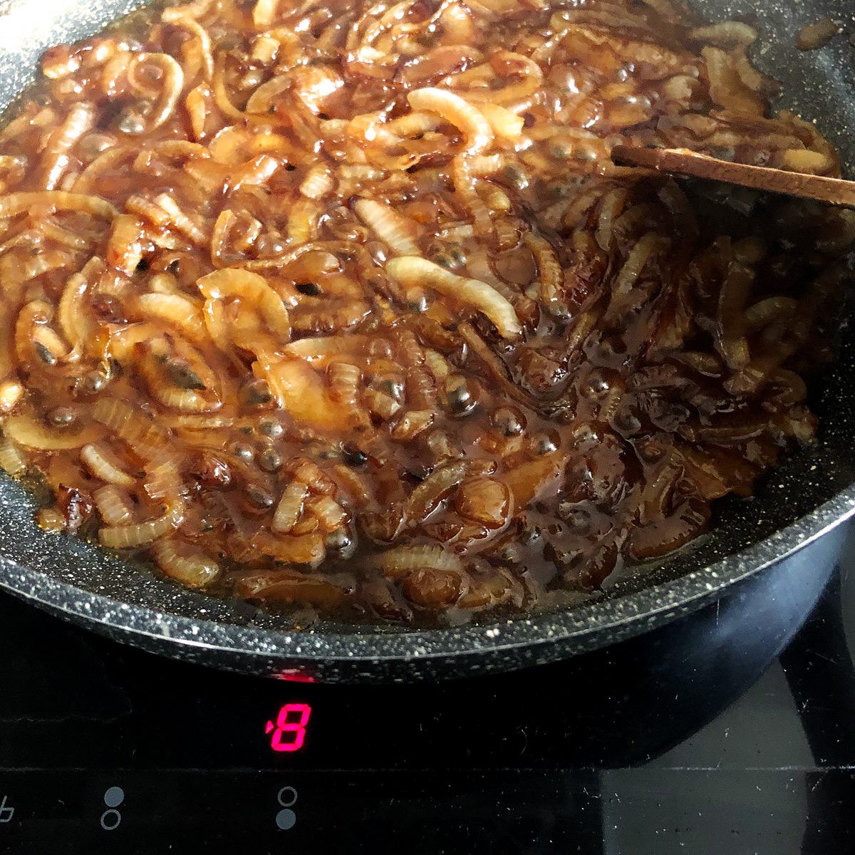 Reducing the onion gravy over high heat.