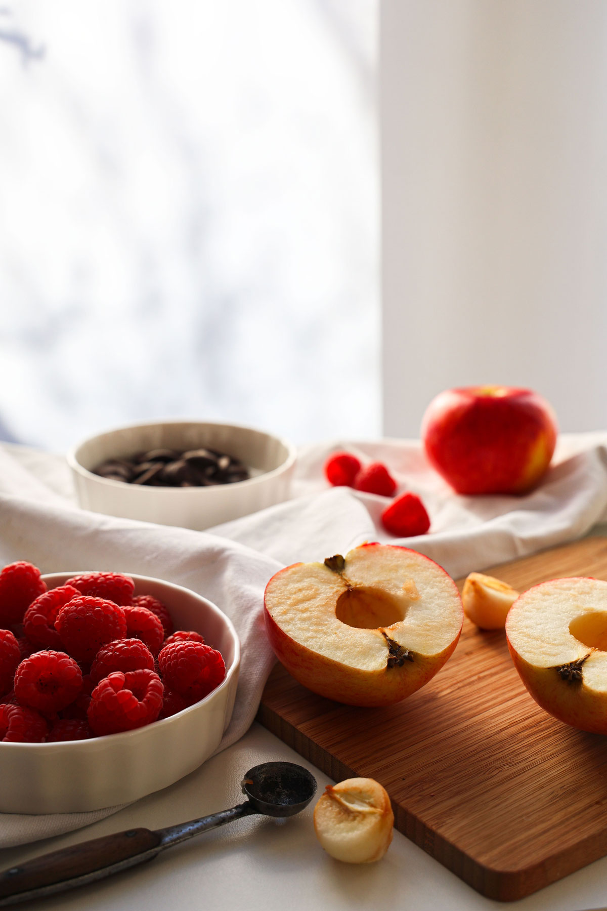 A still life made of ingredients for apple and raspberry crumble.