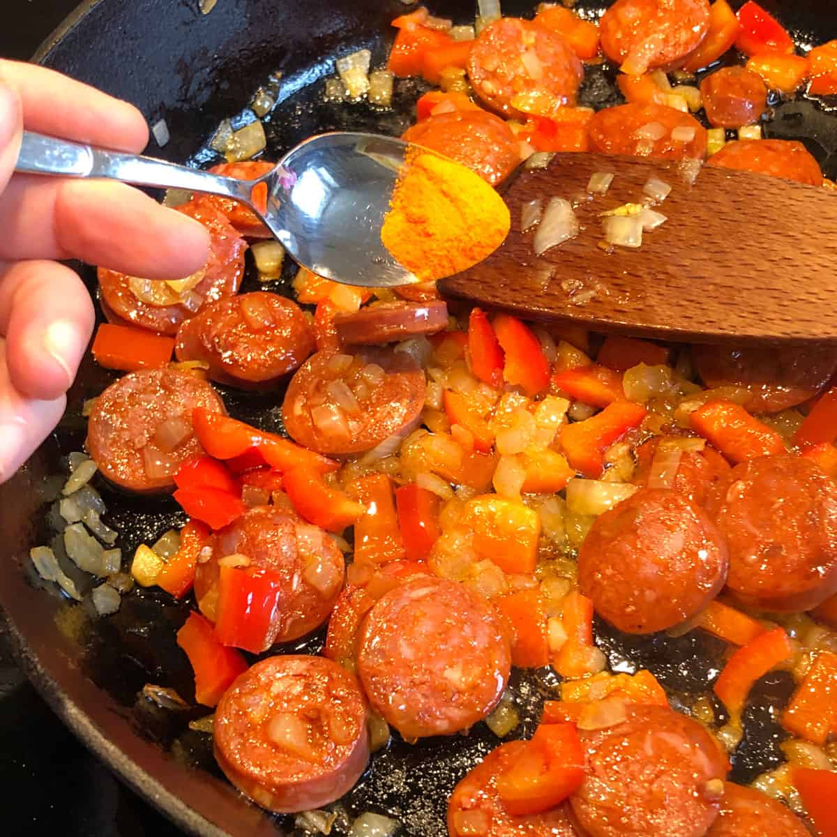 A picture of a recipe step - adding paella seasoning into the fried ingredients.