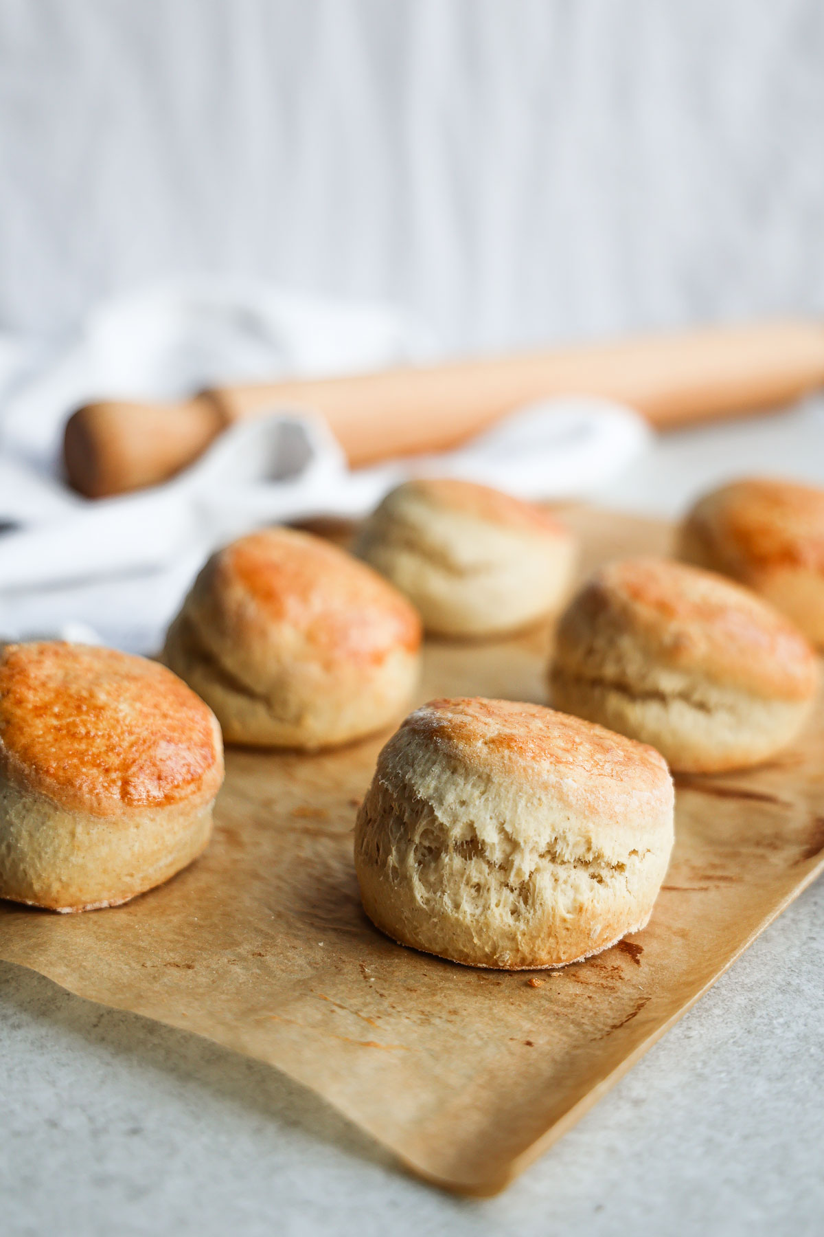 Six scones on brown baking paper.