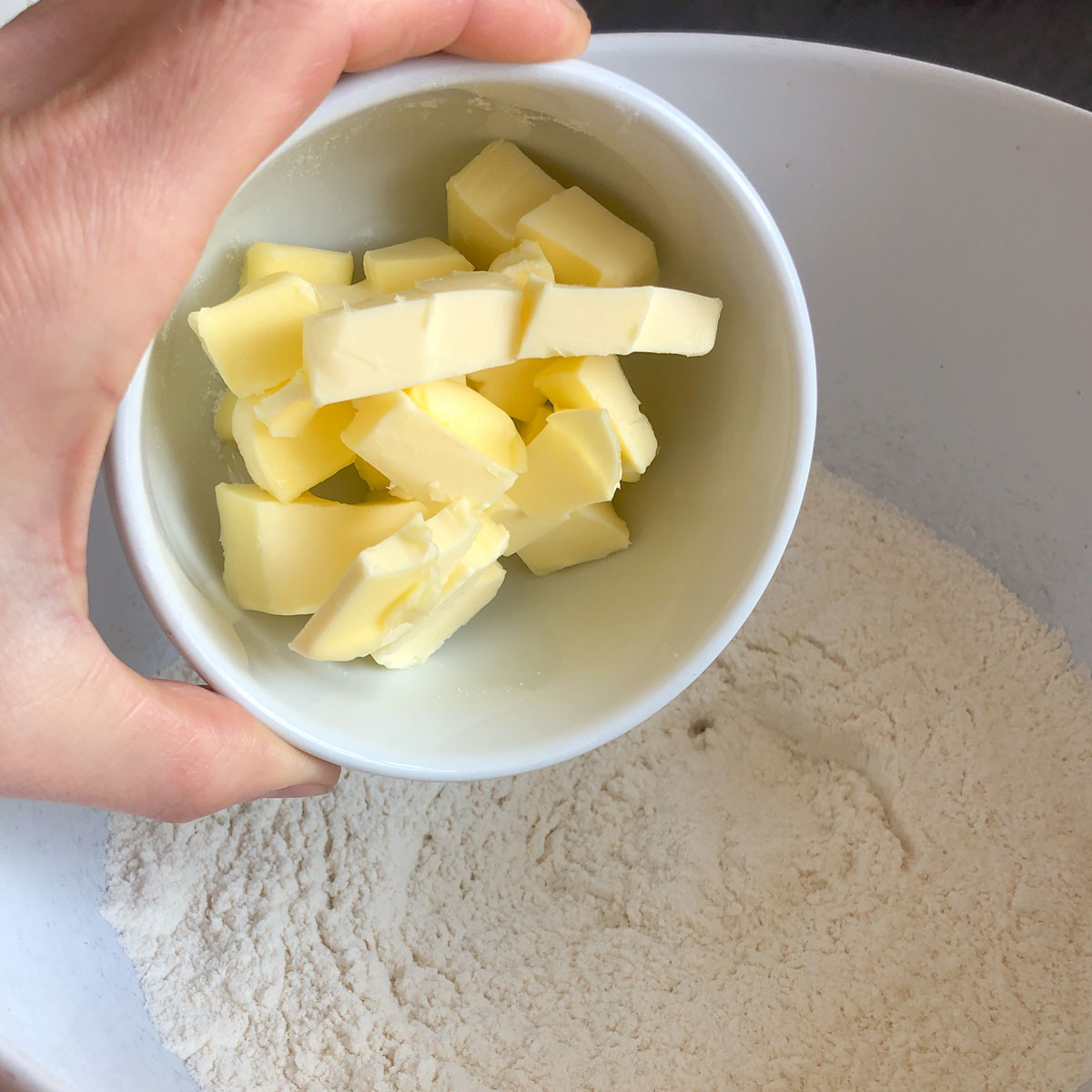 Adding cubed butter into flour.