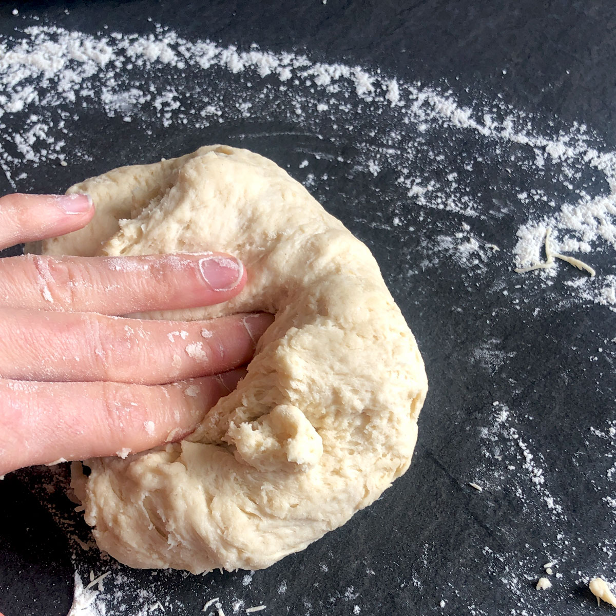 A hand gently folding scone doug.