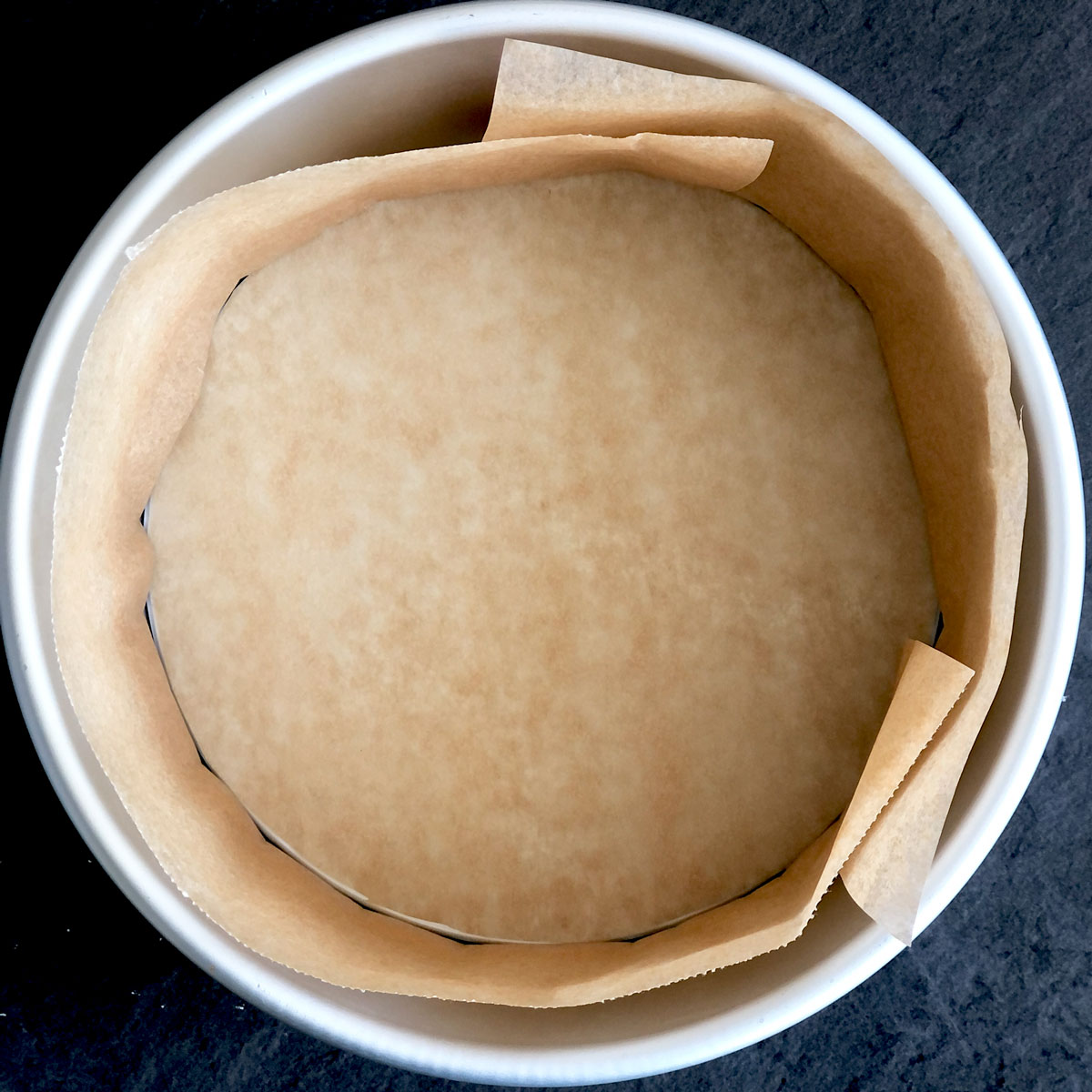 A cake tin lined with baking/parchment paper.