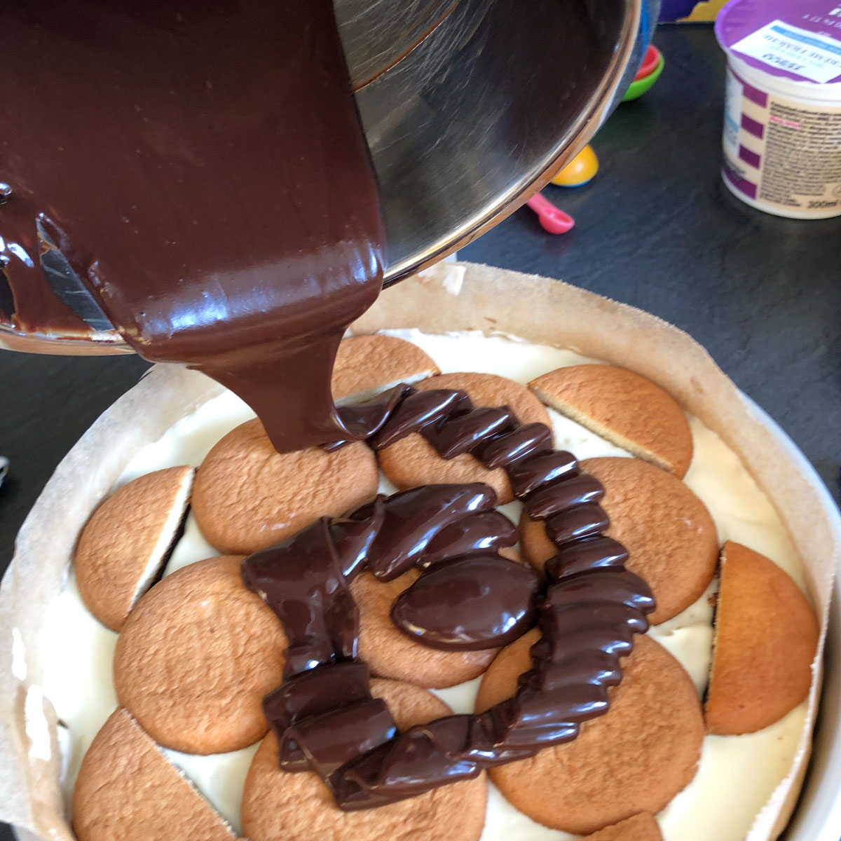 Pouring meted chocolate over Jaffa cakes.