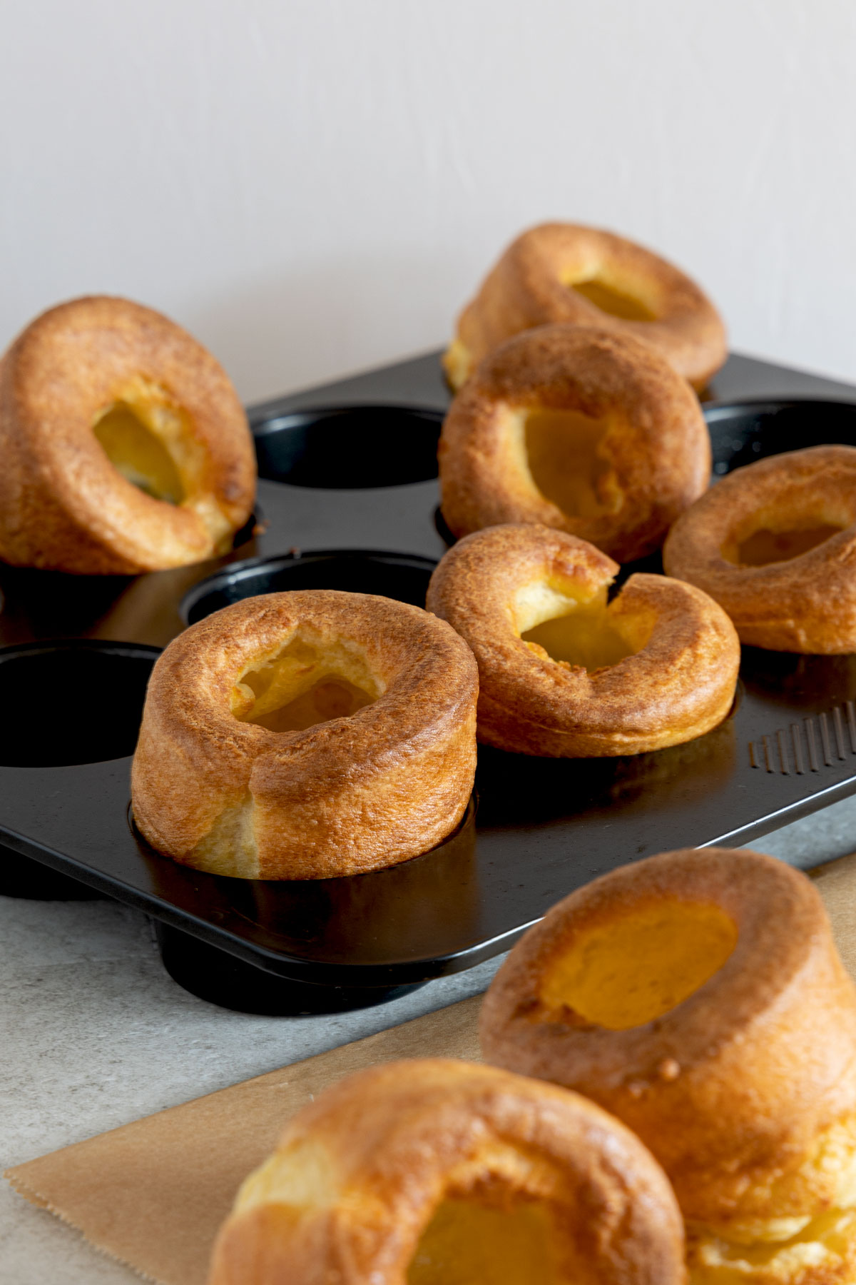 Baked golden brown Yorkshire Puddings on a metal tray