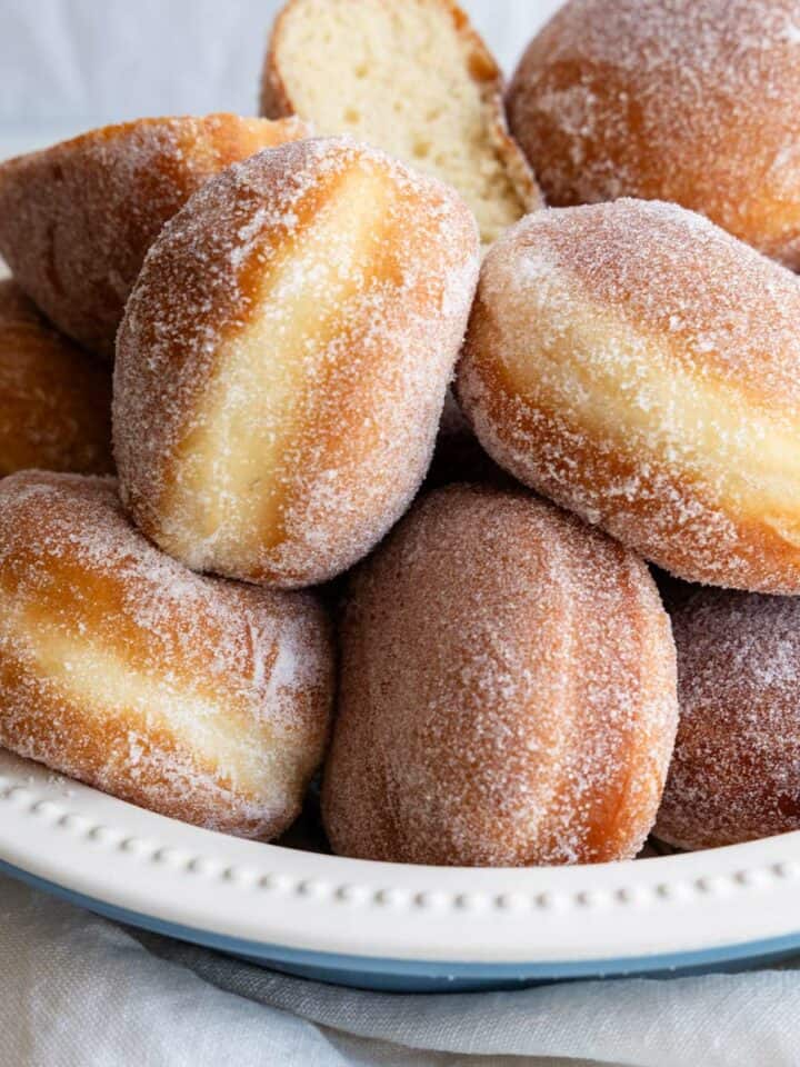 Golden-brown sugar coated doughnuts in a bowl.