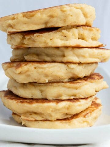 A stack of American-style pancakes on a white plate.